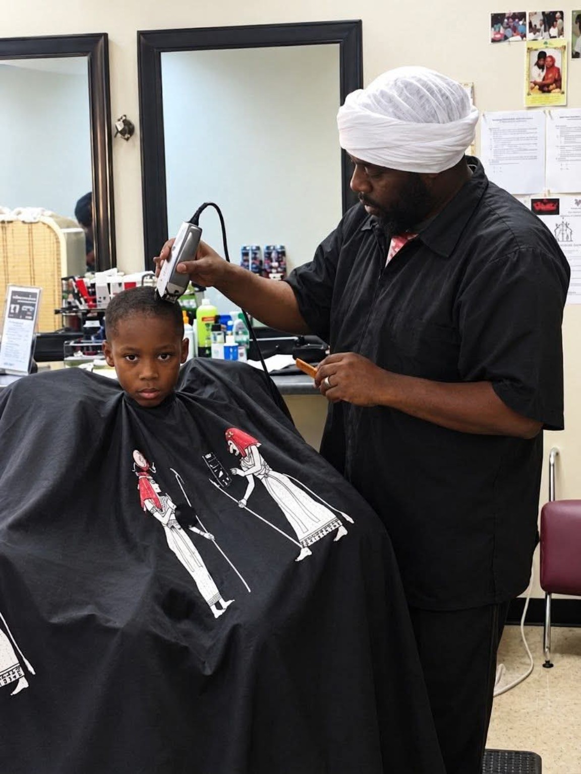 Styles of the Nile barber carefully cutting a young customer's hair